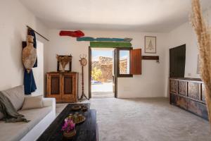 a living room with a couch and a table at Dammuso Il Mulino by DomuSicily in Pantelleria