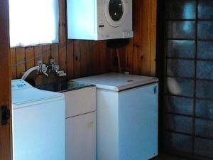 a kitchen with a washing machine and a microwave at The Great Escape - Tairua Holiday Home in Tairua +9 photos