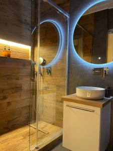 a bathroom with a shower with a sink and a mirror at Boutique Athensairport Apartments in Markopoulo