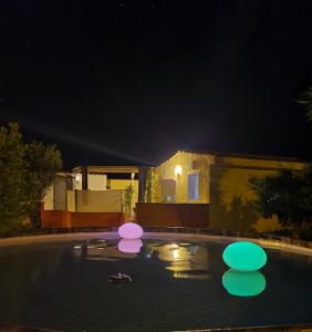 einen Pool in der Nacht mit rosa und violetten Lichtern in der Unterkunft Casa del Sole Irgoli in Irgoli