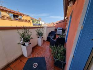 a balcony with chairs and potted plants on a building at I Love Perpignan Duplex Terrasse in Perpignan