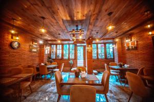 a restaurant with wooden ceilings and tables and chairs at MUSMORE Boutique Hotel in Tbilisi City