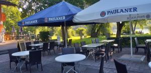 a group of tables and chairs under an umbrella at Highland Accommodation Bavaria in Weilheim in Oberbayern