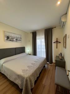 a bedroom with a large bed and a window at Time Holiday´s House in Olhão