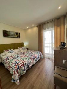 a bedroom with a bed and a large window at Time Holiday´s House in Olhão