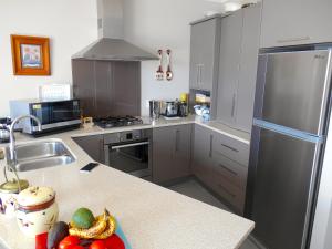 uma cozinha com um frigorífico de aço inoxidável e um lavatório em Absolute Waterfront, Tauranga Apartment em Tauranga