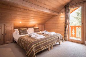 1 dormitorio con 1 cama en una cabaña de madera en Madame Vacances Chalet Silvana, en Méribel