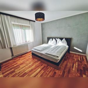 Schlafzimmer mit einem Bett und Holzboden in der Unterkunft Haus Christoph in Winklern