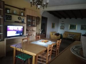 een woonkamer met een eettafel en een televisie bij La Pietra in Chiaramonte Gulfi
