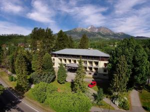 an aerial view of a building with trees and a mountain at APLEND Hotel Lujza Major in Vysoke Tatry - Tatranska Lomnica.