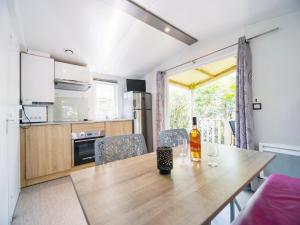 a kitchen and a table with a bottle of wine on it at Camping Paradis 4 étoiles Au Port de L'Houmeau - La Rochelle in LʼHoumeau
