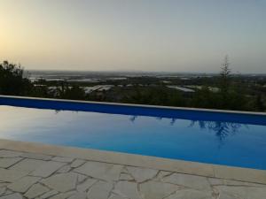 una piscina blu con vista di La Pietra a Chiaramonte Gulfi