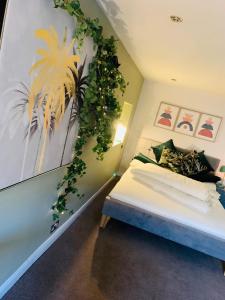 a bedroom with a bed with a plant on the wall at Stable Yard Rooms in Richmond