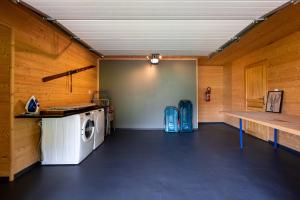 a washer and dryer in a room with wooden walls at Chalet Le Paradis Perdu in Fontpédrouse