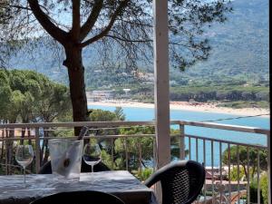 un tavolo con bicchieri da vino su un balcone con vista di VacanzaMareDUE 2 Residence a Campo nell'Elba