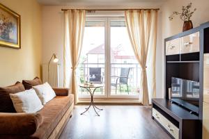 a living room with a couch and a large window at Apartamenty Polanica MyWeek in Polanica-Zdrój
