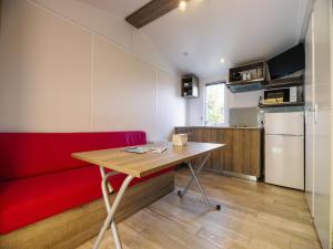 a living room with a red couch and a table at Camping Paradis 4 étoiles Au Port de L'Houmeau - La Rochelle in LʼHoumeau
