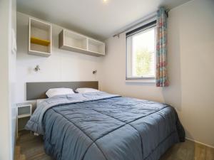 a bedroom with a bed and a window at Camping Paradis 4 étoiles Au Port de L'Houmeau - La Rochelle in LʼHoumeau