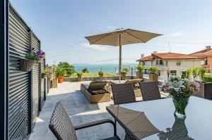 a patio with a table and chairs and an umbrella at Апартаменти Ивайло / Ivaylo apartments in Burgas City