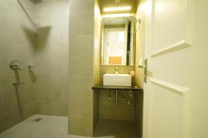 a bathroom with a sink and a shower with a mirror at Octave Orchid Vista in Gurgaon