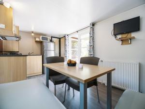 a kitchen and dining room with a table and chairs at Camping Paradis 4 étoiles Au Port de L'Houmeau - La Rochelle in LʼHoumeau