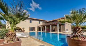 a swimming pool in a house with two palm trees at Villa Delphin 375 Fantastic villa with amazing outside space, Aphrodite Hills in Kouklia
