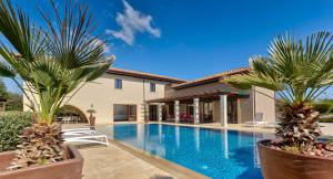 una piscina en una casa con dos palmeras en Villa Delphin 375 Fantastic villa with amazing outside space, Aphrodite Hills, en Kouklia