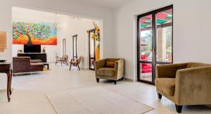 una sala de estar con sillas y una pintura en la pared en Villa Delphin 375 Fantastic villa with amazing outside space, Aphrodite Hills, en Kouklia