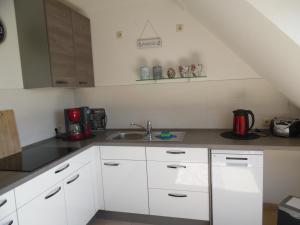 una cucina con mobili bianchi e un lavandino di Landhaus Martina a Krummhörn