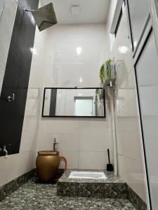 Auranad Guest House Tanah Merah Wifi-Netflix في Kampong Tanah Merah: حمام مع حوض ومرآة