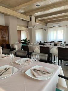 Agriturismo Borgo Furma في إينّا: غرفة طعام مع طاولات وكراسي بيضاء