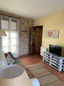 a living room with a couch and a flat screen tv at La Casa de Baix in Torre del Compte