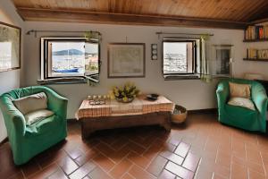 a living room with two green chairs and a table at Vista Porto in Alghero