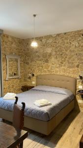 a bedroom with a bed and a stone wall at Agriturismo Borgo Furma in Enna