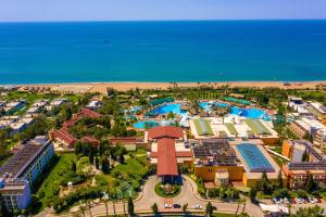 an aerial view of a resort with a pool and the ocean at AQI Pegasos World in Side