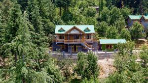 a wooden house in the middle of a forest at SaffronStays Kesar Villa, Manali - beautiful villa amidst an apple orchard - All clear roads in Manāli