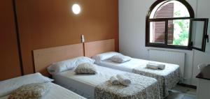2 camas individuales en una habitación con ventana en New Hortaleza Coliving, en Madrid