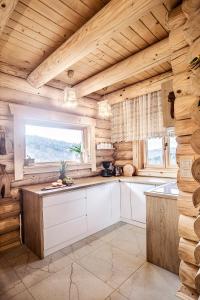 eine Küche mit Holzwänden und einem großen Fenster in der Unterkunft Pyrgielówka- chata Roztoki in Stryszawa