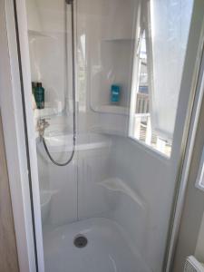 a white bathroom with a shower and a toilet at KERLANN 4 ETOILES MOBIL HOME 3 CHS 1 SDB Pont aven in Pont-Aven