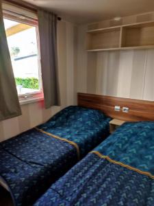 a hotel room with two beds and a window at KERLANN 4 ETOILES MOBIL HOME 3 CHS 1 SDB Pont aven in Pont-Aven