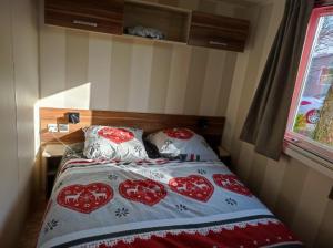 a bedroom with a bed with red hearts on it at KERLANN 4 ETOILES MOBIL HOME 3 CHS 1 SDB Pont aven in Pont-Aven