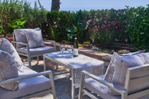 een tafel met 2 stoelen en een fles wijn bij To Be Capri Sea view Rooms in Capri