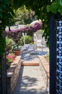 a garden with chairs and flowers in a yard at To Be Capri Sea view Rooms in Capri