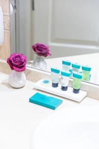 - un comptoir de salle de bains avec un bouquet de produits de maquillage dans l'établissement Hotel Serrano, à Madrid