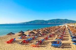 a bunch of chairs and umbrellas on a beach at Villa Periklis Madytos 1st Floor Independent House in Néa Mádhitos