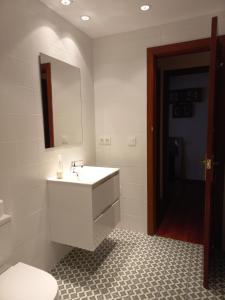 a bathroom with a white sink and a mirror at Apartamento Catalina, céntrico, tranquilo y luminoso in Llanes