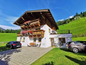 ein Haus mit zwei Autos, die davor geparkt sind in der Unterkunft Chalet Rehlein in Großarl