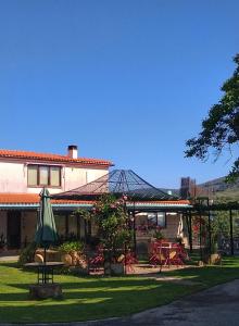 a patio with an umbrella and a table and chairs at Casa Rural del Corral in Malpartida de Plasencia