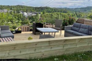 a patio with couches and a table on a deck at Modern and Cozy home with an outstanding view in Asker