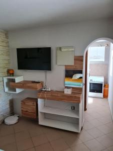 Zimmer mit einem Schreibtisch, einem TV und einem Bett in der Unterkunft Studio apartment Ivan in Čunski